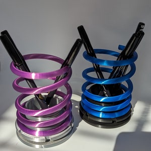 Soporte para bolígrafos con sistema de suspensión en espiral