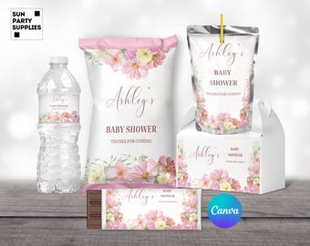 May include: A set of baby shower party favors with a floral design. The favors include a water bottle, a bag of chips, a box of chocolates, a juice pouch, and a favor box. The favors are decorated with pink and white flowers and the text "Ashley's Baby Shower Thanks for Coming!"