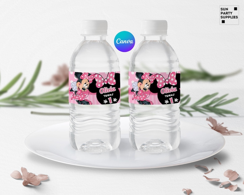 May include: Two clear plastic water bottles with pink and black Minnie Mouse themed labels. The labels feature Minnie Mouse with a pink bow and polka dots. The text on the labels reads "Olivia turns 1".