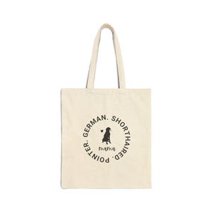 May include: A beige tote bag with a black circle design that says "German Shorthaired Pointer. Mama." with a silhouette of a dog inside the circle.