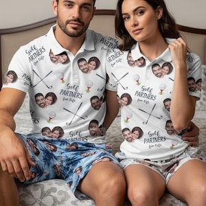 May include: Two white polo shirts with a repeating pattern of golf clubs, golf balls, and a couple's faces, featuring the text Golf Partners for life. The shirts are paired with blue patterned shorts and white patterned shorts respectively.
