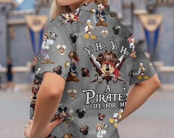 May include: Gray button-up shirt with a pirate-themed design featuring Mickey Mouse and other Disney characters. The shirt has short sleeves and the text "Yo Ho, Yo Ho" and "A Pirate's Life for Me".