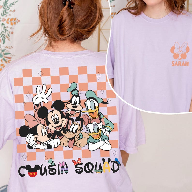 May include: A lilac t-shirt with a graphic of Disney characters, including Mickey and Minnie Mouse, Goofy, Donald and Daisy Duck. The back of the shirt has a checkered pattern and the words "Cousin Squad". The front has a small graphic and the name "Sarah".