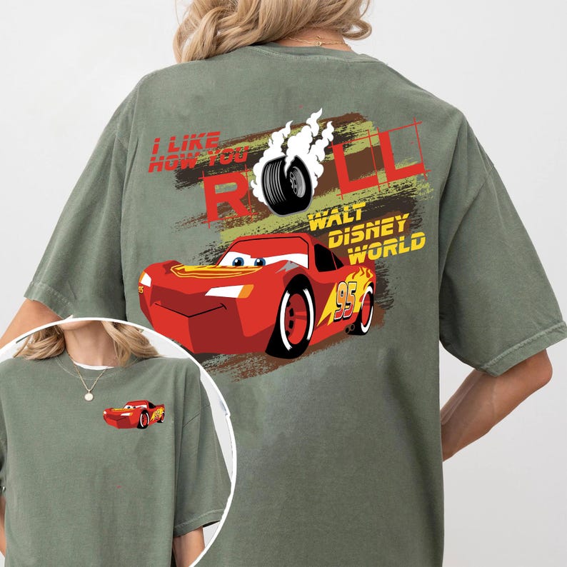 Puede incluir: Camiseta verde oliva con un dise&ntilde;o de Rayo McQueen de la pel&iacute;cula Cars. El dise&ntilde;o incluye el texto "I Like How You Roll" y "Walt Disney World". Una versi&oacute;n m&aacute;s peque&ntilde;a del coche est&aacute; en la parte delantera.
