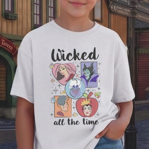 K&ouml;nnte beinhalten: Wei&szlig;es T-Shirt mit dem Wort "Wicked" &uuml;ber einer farbenfrohen Grafik von Zeichentrick-B&ouml;sewichten. Die Grafik enth&auml;lt Bilder von Charakteren in Pink, Lila, Blau und Rot. Der Satz "all the time" ist darunter gedruckt.