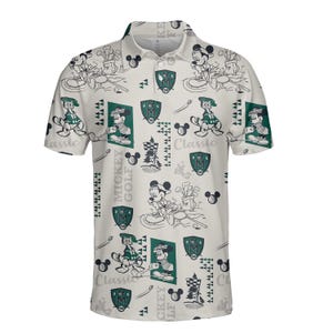 May include: Cream polo shirt with a repeating pattern of Mickey Mouse playing golf. The design includes golf-related graphics, the words "Mickey Golf Classic," and a shield emblem. The shirt has a collared neckline and short sleeves.