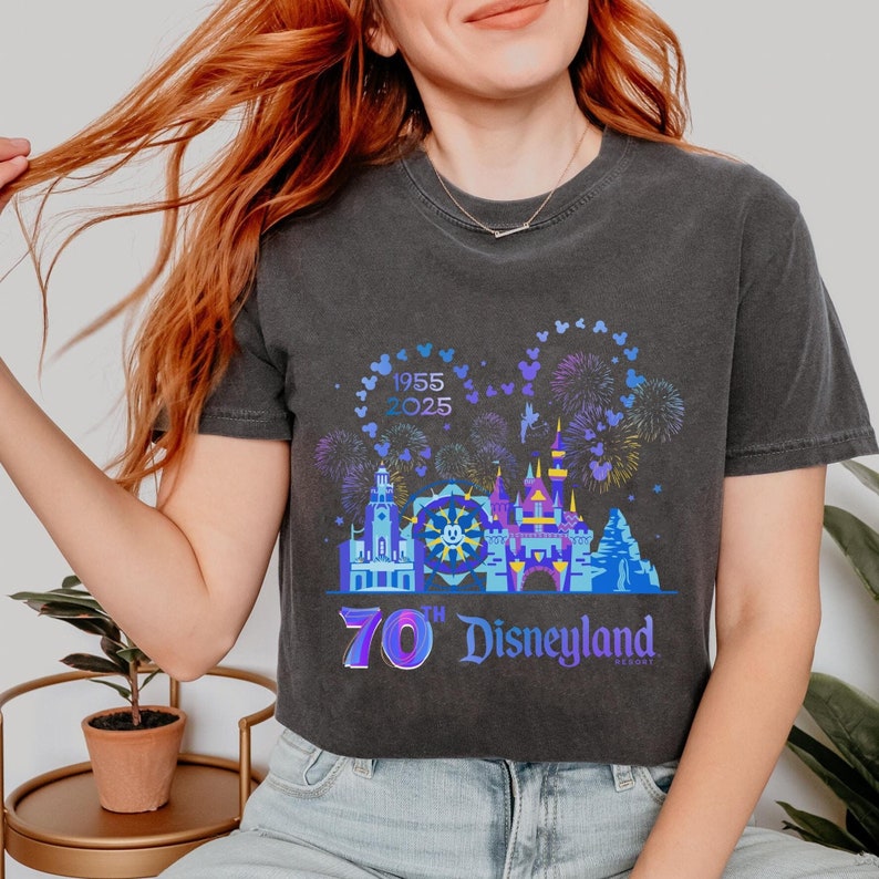 May include: A black cropped t-shirt with a graphic of Disneyland's iconic castle and fireworks. The graphic also includes the text "1955 2025" and "70th Disneyland Resort".