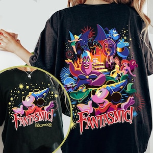 May include: Dark grey t-shirt with a vibrant graphic of Mickey Mouse in a wizard's hat, the word "Fantasmic!" in red, and other Disney characters. The design includes fireworks and the text "Hollywood".