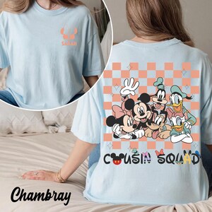 May include: Pale blue t-shirt featuring a Disney character graphic on the back, including Mickey and Minnie Mouse, Goofy, and Donald Duck. The words "Cousin Squad" are printed below. The front has the name "Sarah" and a character graphic.