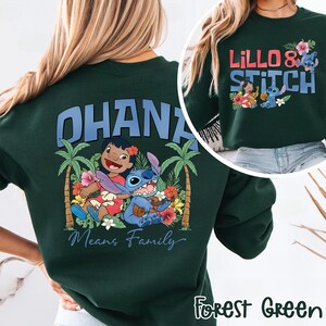 May include: Forest green sweatshirt featuring the characters Lilo and Stitch. The front design says "Lillo & Stitch" with floral accents. The back design says "OHANA Means Family" with Lilo, Stitch, palm trees, and flowers.