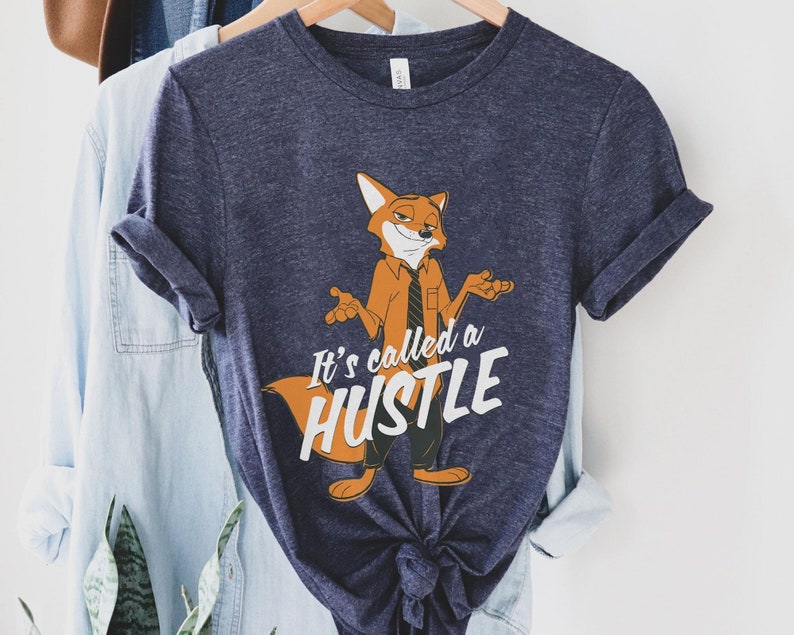 May include: A navy blue t-shirt with a cartoon fox wearing a tie and the text "It's called a hustle".