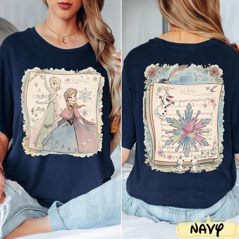 May include: Navy blue t-shirt featuring a front and back design. The front showcases Elsa and Anna from Frozen, while the back displays Olaf, snowflakes, and sheet music with the text "Let It Go".