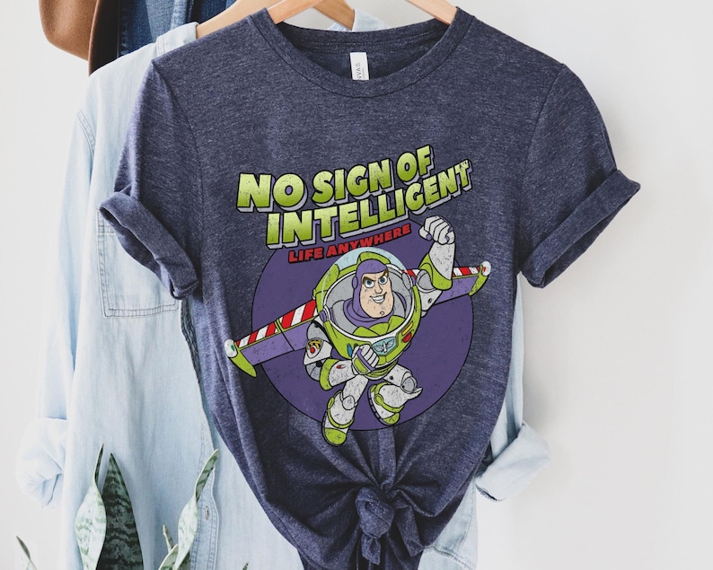 May include: A navy blue t-shirt with a distressed graphic of Buzz Lightyear from Toy Story. The graphic includes the text "No Sign of Intelligent Life Anywhere".