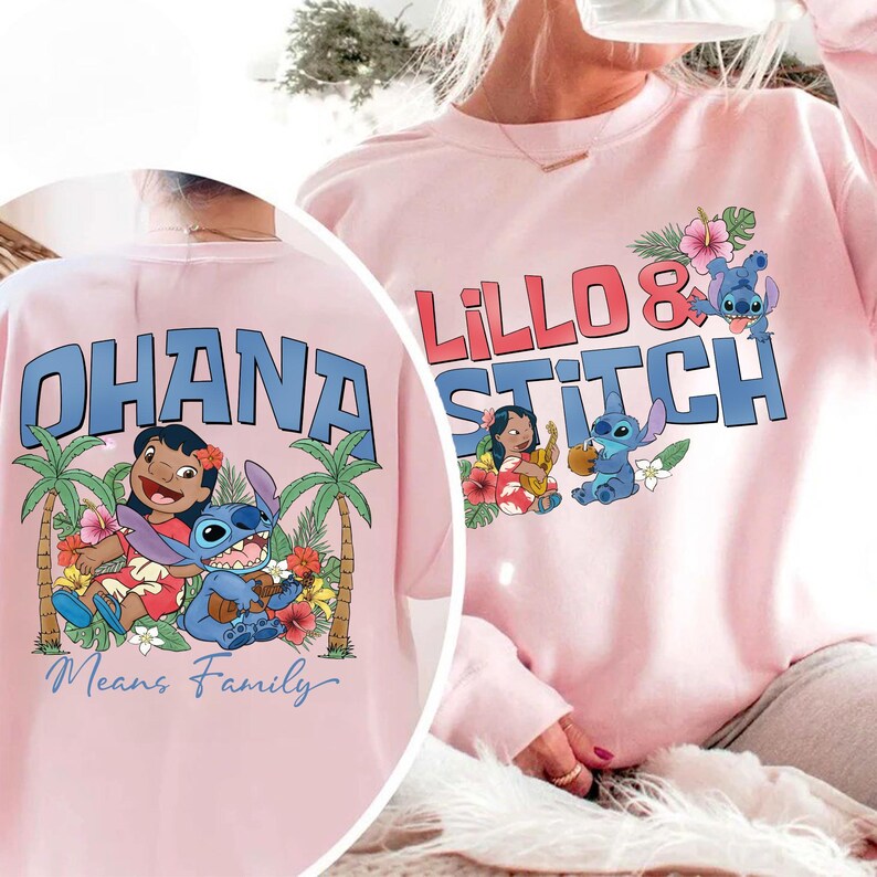 May include: Pink sweatshirt featuring the words "Lillo & Stitch" in red and blue, with cartoon characters and floral accents. The back of the shirt displays "Ohana Means Family" with a graphic of the characters and palm trees.