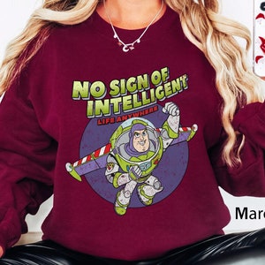 May include: Maroon sweatshirt with a graphic of Buzz Lightyear from Toy Story. The graphic says "No sign of intelligent life anywhere".