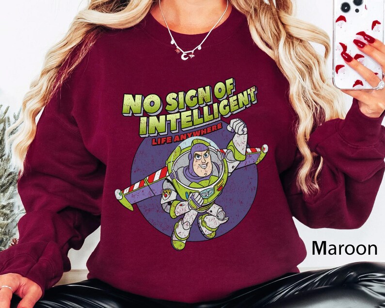 May include: Maroon sweatshirt with a graphic of Buzz Lightyear from Toy Story. The graphic says "No sign of intelligent life anywhere".
