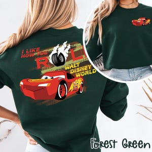 Puede incluir: Sudadera verde bosque con un dise&ntilde;o de Rayo McQueen de la pel&iacute;cula Cars. El dise&ntilde;o trasero incluye el texto "I LIKE HOW YOU ROLL" y "WALT DISNEY WORLD". Una versi&oacute;n m&aacute;s peque&ntilde;a del coche est&aacute; en la parte delantera.