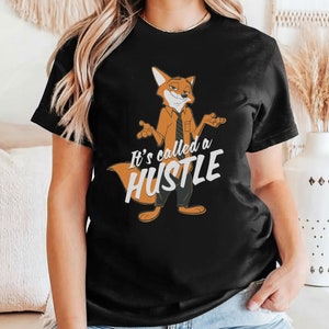 May include: Black t-shirt featuring a cartoon fox wearing a tie and saying "It's called a hustle".