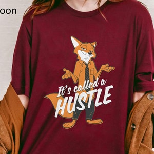 May include: A maroon t-shirt with a cartoon fox wearing a tie and the text "It's called a hustle".