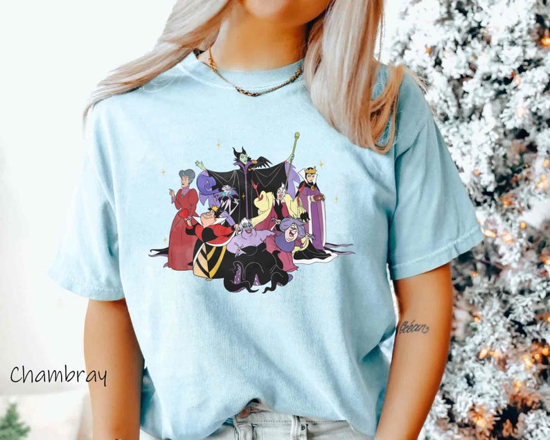 May include: A light blue t-shirt with a graphic print of Disney villains, including Maleficent, Ursula, Cruella de Vil, and the Evil Queen. The villains are depicted in a group, with Maleficent in the center.