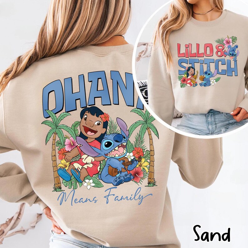 May include: Sand-colored sweatshirt featuring a graphic of Lilo and Stitch with the text "OHANA Means Family." The design includes palm trees, flowers, and the characters Lilo and Stitch. A smaller image shows the text "Lillo & Stitch."