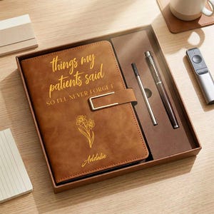 May include: A brown leather journal with the text "things my patients said so I'll never forget" and a floral design. The journal is in a gift box with two pens. The name "Addalie" is printed on the journal.