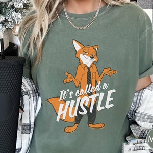 May include: A green t-shirt with a cartoon fox wearing a tie and the text "It's called a hustle".