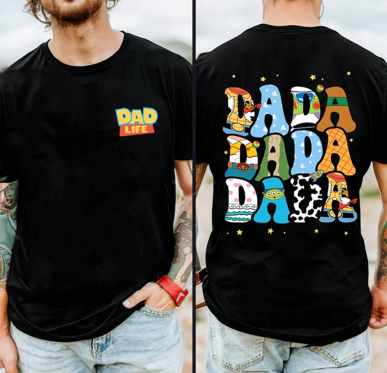 Op de afbeelding: Zwart T-shirt met de tekst "DAD LIFE" in een kleurrijk ontwerp op de voorkant. De achterkant van het shirt heeft het woord "DADA" in een speelse, veelkleurige lettertype met steraccenten, wat een leuk en opvallend ontwerp cre&euml;ert.