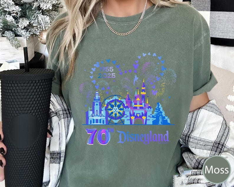 May include: A green t-shirt with a graphic of a castle, fireworks, and a Ferris wheel. The text "70th Disneyland" is printed on the shirt.