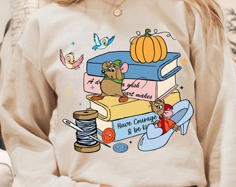 May include: Beige sweatshirt with a colorful graphic featuring cartoon mice, birds, a pumpkin, and books. The design includes the text "A dream a wish your heart makes" and "Have Courage & be kind."