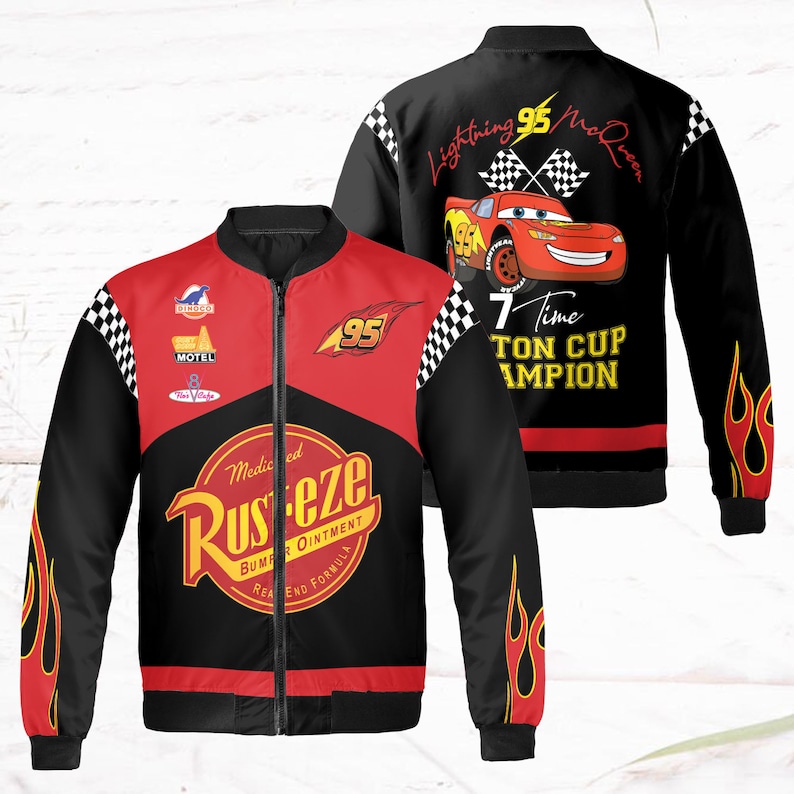 May include: A black and red bomber jacket with a zipper closure. The jacket features a checkered pattern, flames, and a cartoon image of Lightning McQueen from the movie Cars. The text "Lightning McQueen" and "7 Time Piston Cup Champion" is printed on the back of the jacket. The front of the jacket features the text "Rusteze" and "Medicated Bumper Ointment".