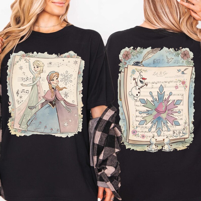 May include: Black t-shirt featuring a colorful illustration of Elsa and Anna from Frozen, with musical notes and a snowflake design. The back of the shirt shows Olaf, a snowflake, and the text "Let It Go".