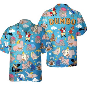 May include: A light blue button-up shirt featuring a repeating pattern of Dumbo and other characters from the animated film. The word "DUMBO" is printed in orange on the back of the shirt. The shirt has short sleeves and a classic collar.