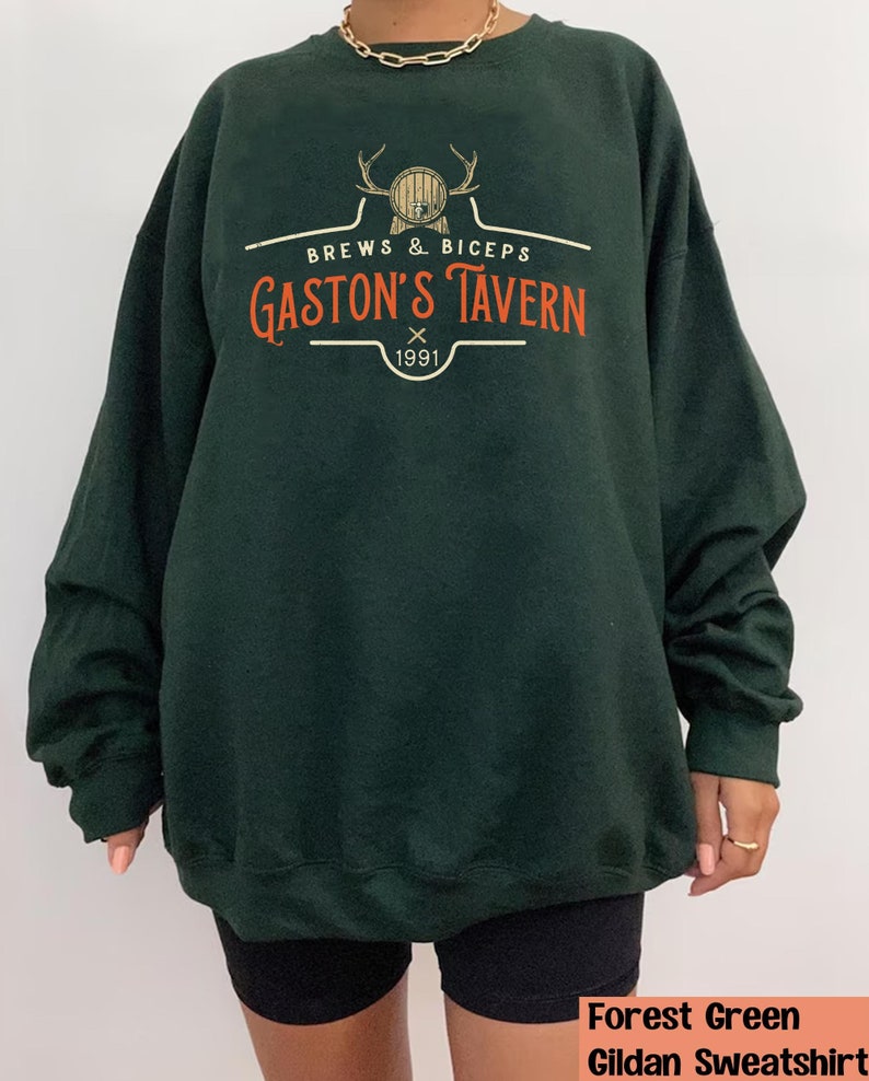 Op de afbeelding: Forestgroen Gildan sweatshirt met een vintage-stijl logo met de tekst "Brews & Biceps Gaston's Tavern 1991".