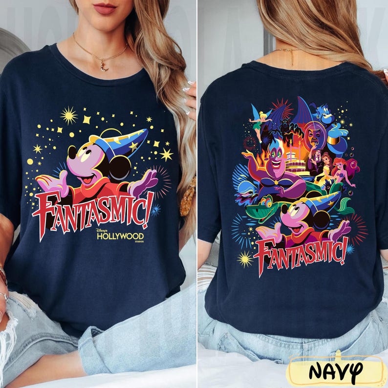 May include: Navy blue t-shirt with a vibrant graphic of Mickey Mouse in a sorcerer's hat and the text "FANTASMIC! Hollywood". The back of the shirt showcases various Disney characters. The word "NAVY" is at the bottom.