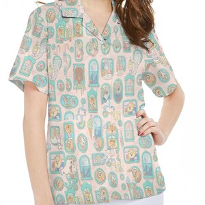 Puede incluir: Camisa de manga corta con fondo rosa claro y un patrón repetido de retratos de animales de dibujos animados en marcos ornamentados. Los marcos están delineados en verde azulado, y la camisa tiene un cuello clásico.