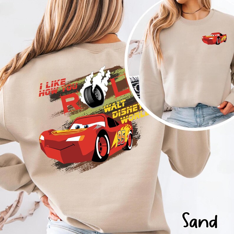 Puede incluir: Sudadera color arena con un gr&aacute;fico de Rayo McQueen de la pel&iacute;cula Cars. El dise&ntilde;o incluye el texto "I Like How You Roll" y "Walt Disney World". Una imagen m&aacute;s peque&ntilde;a de Rayo McQueen est&aacute; en la parte superior derecha.