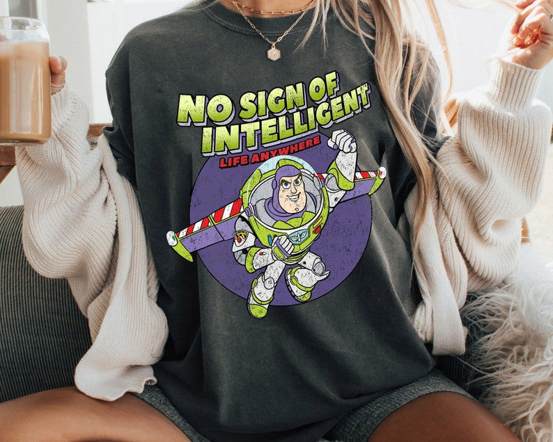 May include: A dark gray t-shirt with a distressed graphic of Buzz Lightyear from Toy Story. The graphic says "No Sign of Intelligent Life Anywhere".
