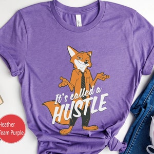 May include: Purple t-shirt featuring a cartoon fox wearing a tie and the text "It's called a hustle".