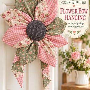 May include: A quilted fabric flower hanging decoration featuring alternating sage green floral and pink gingham petals with a dark gray quilted center. A label reads: COSY QUILTER FLOWER BOW HANGING A step-by-step sewing pattern.