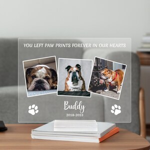 May include: A clear acrylic memorial plaque with three photos of a bulldog, the text "You left paw prints forever in our hearts", the name "Buddy", and the dates "2018-2023".