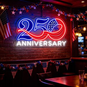 Pode incluir: Uma placa de néon numa parede de tijolo com a inscrição "250th Anniversary" em azul, vermelho e branco. Bandeiras americanas e decorações patrióticas adornam o bar, criando um ambiente festivo. A placa é o ponto focal.