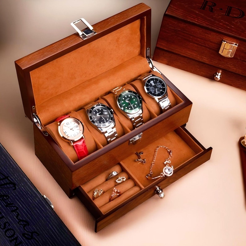 May include: A wooden watch box with a drawer. The top compartment has five slots for watches. The drawer has a ring holder and a space for jewelry. The box is closed and the lid is slightly ajar.
