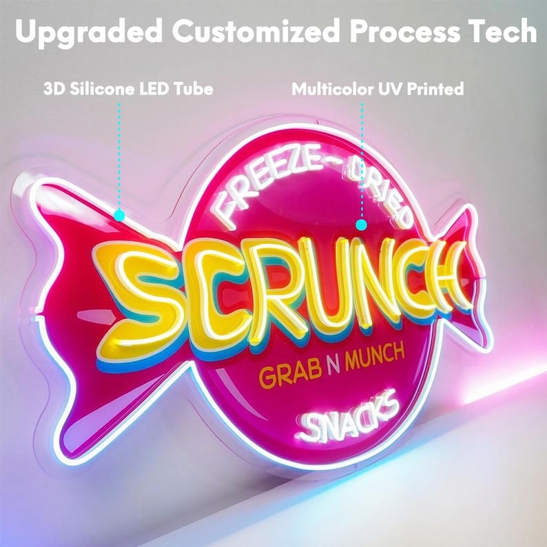 Pode incluir: Um letreiro de n&eacute;on em forma de rebu&ccedil;ado com o texto "FREEZE-DRIED SCRUNCH GRAB N MUNCH SNACKS" em amarelo e branco. O letreiro utiliza tubos LED de silicone 3D e impress&atilde;o UV multicolorida, com o texto "Upgraded Customized Process Tech".