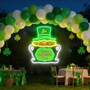 May include: A neon sign with a green leprechaun hat and pot of gold, with the text "Happy St. Patrick's Day!" surrounded by green and white balloons. The scene is set outdoors with tables and chairs.
