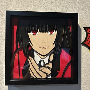 May include: A framed wooden art piece featuring a stylized anime character with black hair and red eyes. The character is wearing a black suit with a red lining and a white collared shirt. The artwork is set against a red background.