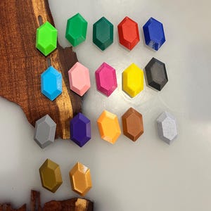 Pu&ograve; includere: Una collezione di diciassette piccoli oggetti esagonali a forma di gemma in vari colori solidi, tra cui verde lime, verde bosco, rosso, blu, azzurro, rosa, magenta, giallo, nero, grigio, viola, arancione, marrone, bianco, oro e bronzo.