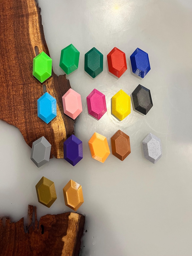 Pu&ograve; includere: Una collezione di diciassette piccoli oggetti esagonali a forma di gemma in vari colori solidi, tra cui verde lime, verde bosco, rosso, blu, azzurro, rosa, magenta, giallo, nero, grigio, viola, arancione, marrone, bianco, oro e bronzo.