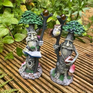 Pu&ograve; includere: Due statue da giardino fantasiose raffiguranti figure simili ad alberi con lunghe barbe, che tengono bastoni sormontati da globi. Una figura tiene un libro, l'altra ha un gufo. Dipinte in verde, marrone e grigio, su legno.