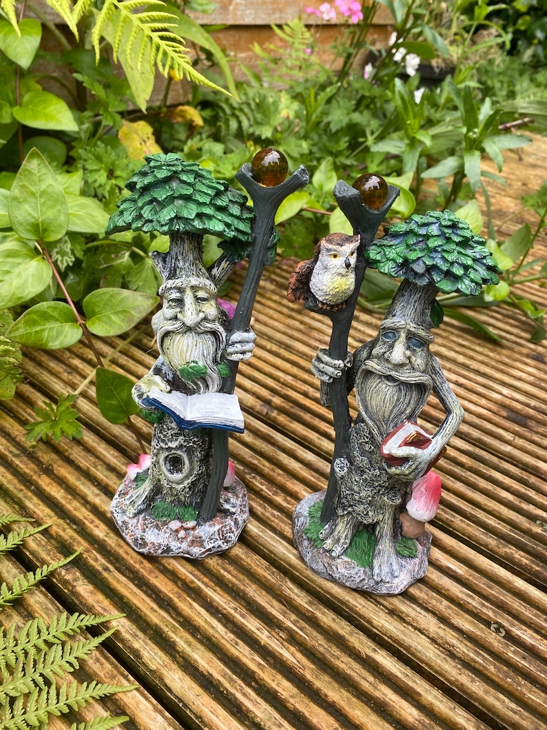 Pu&ograve; includere: Due statue da giardino fantasiose raffiguranti figure simili ad alberi con lunghe barbe, che tengono bastoni sormontati da globi. Una figura tiene un libro, l'altra ha un gufo. Dipinte in verde, marrone e grigio, su legno.